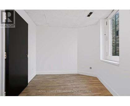 A white room with a black door and a window with a white frame.