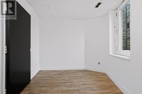 A white room with a black door and a window with a white frame.