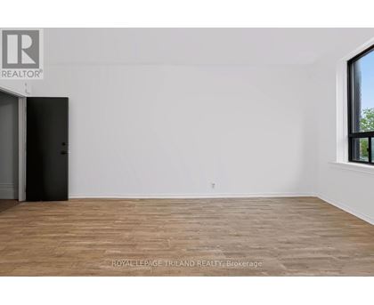 A room with a wooden floor and a door on the left side.