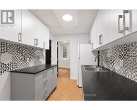 A kitchen with black and white tiles on the backsplash.