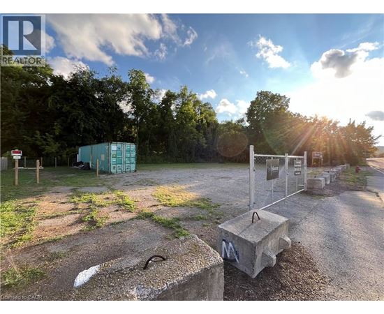 A sunny day at a construction site with a blue container and a concrete block in the foreground.