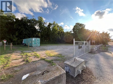 A sunny day at a construction site with a blue container and a concrete block in the foreground.