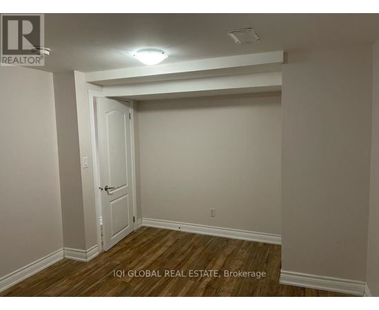 A room with a door and a brokerage sign.