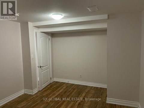 A room with a door and a brokerage sign.