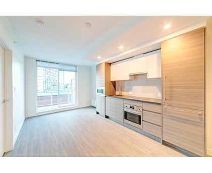 A modern kitchen with wooden cabinets and stainless steel appliances.