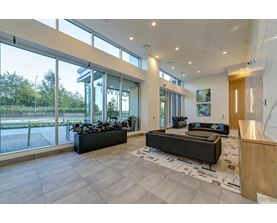 A spacious living room with a large window and a view of the outdoors.