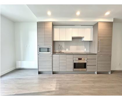 A modern kitchen with a microwave, oven, and cabinets.