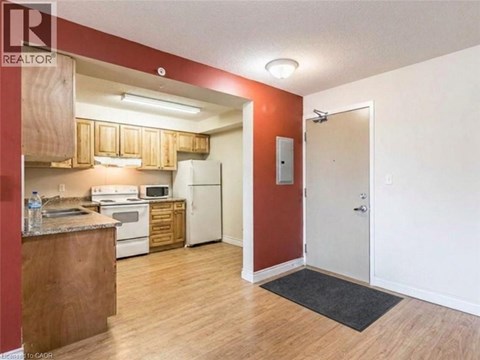A kitchen with white appliances and wooden cabinets.