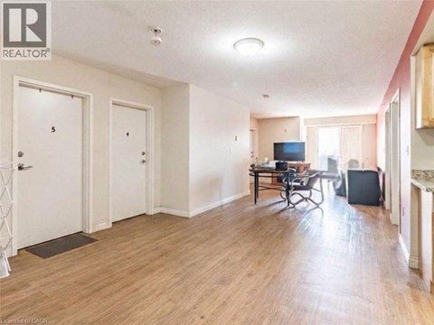 A living room with a television and a dining table.