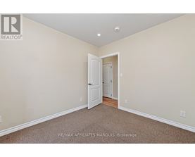 A room with a carpeted floor and a doorway leading to another room.