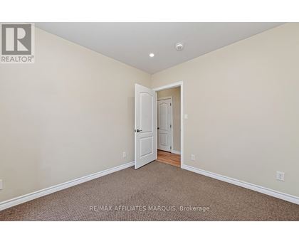 A room with a carpeted floor and a doorway leading to another room.