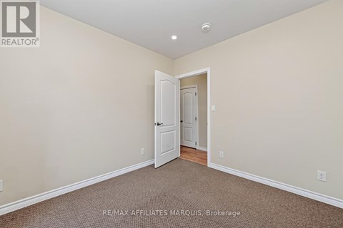 A room with a carpeted floor and a doorway leading to another room.