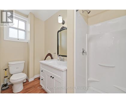 A white bathroom with a toilet, sink, and mirror.