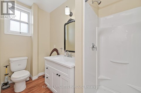 A white bathroom with a toilet, sink, and mirror.