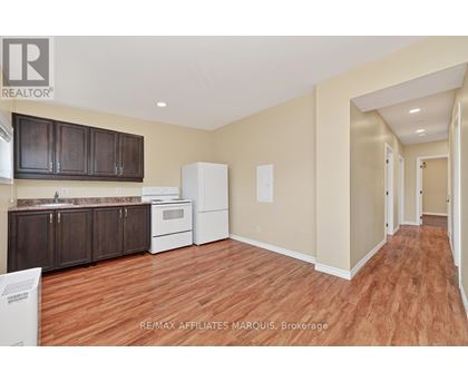 A kitchen with brown cabinets and a white refrigerator.
