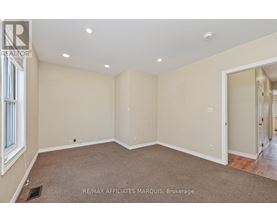 A spacious room with beige walls and carpeted floor.