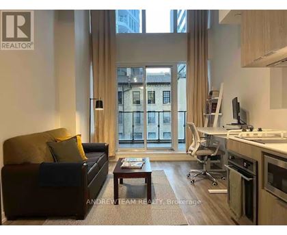 A living room with a brown couch and a coffee table in front of a large window.