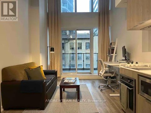A living room with a brown couch and a coffee table in front of a large window.