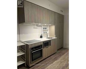 A modern kitchen with wooden cabinets and stainless steel appliances.