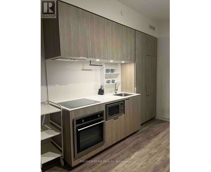 A modern kitchen with wooden cabinets and stainless steel appliances.