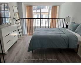 A bedroom with a bed, nightstand, and chair.