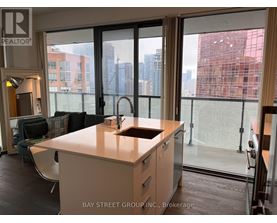 A kitchen with a sink and a window overlooking a cityscape.