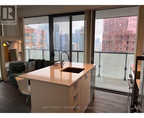 A kitchen with a sink and a window overlooking a cityscape.