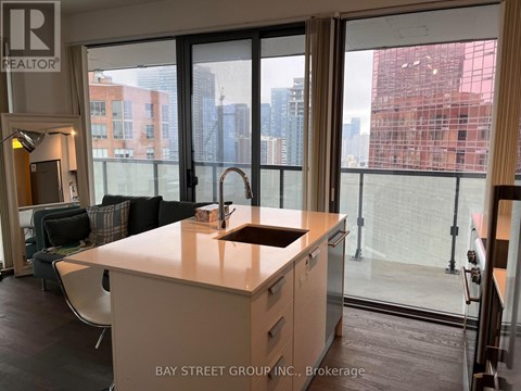 A kitchen with a sink and a window overlooking a cityscape.