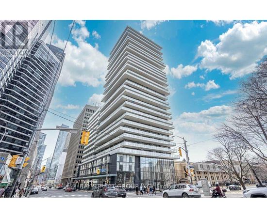 A tall, modern building with a curved facade stands in the middle of a bustling city street.