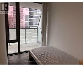 A bedroom with a large bed and a view of the city through the window.