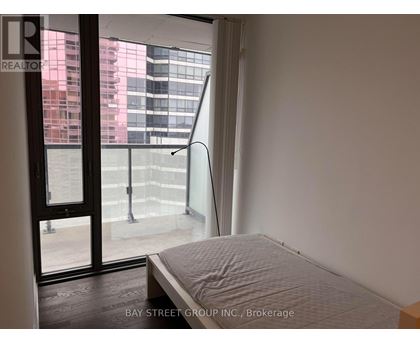 A bedroom with a large bed and a view of the city through the window.
