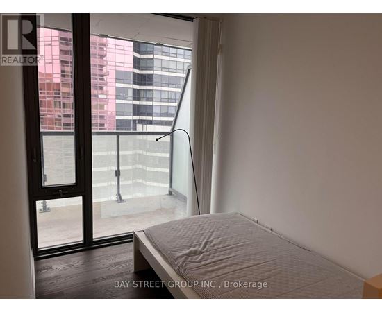 A bedroom with a large bed and a view of the city through the window.