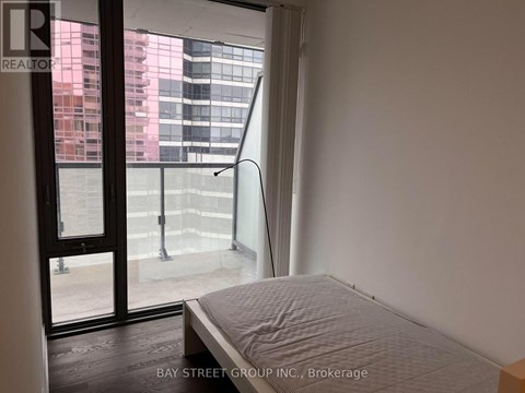 A bedroom with a large bed and a view of the city through the window.