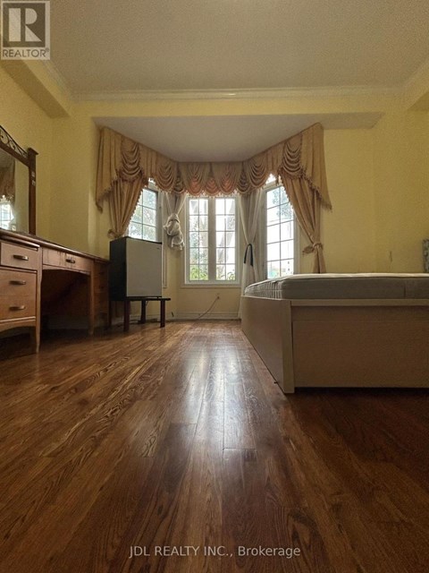A bedroom with a bed, dresser, and window.