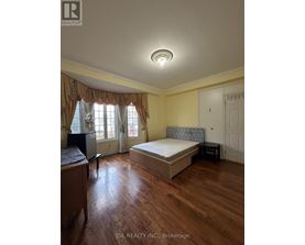 A bedroom with a bed, nightstand, and window with curtains.