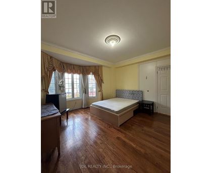 A bedroom with a bed, nightstand, and window with curtains.