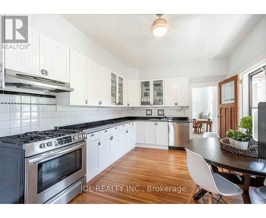 A modern kitchen with white cabinets and a black stove top.