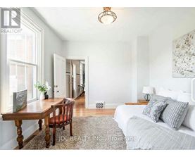 A bedroom with a bed, a table, and a chair.