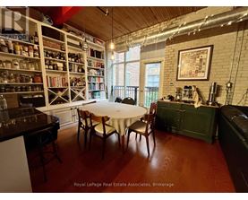 A dining room with a table set for two and a bookshelf filled with books.