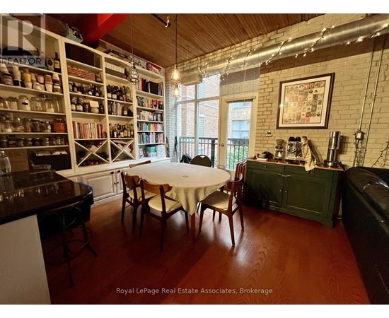 A dining room with a table set for two and a bookshelf filled with books.