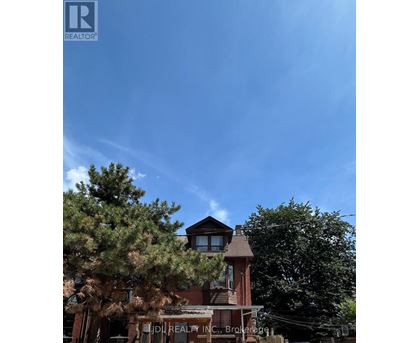 A building with a sign that says "IDI REALTY INC." is in front of some trees.