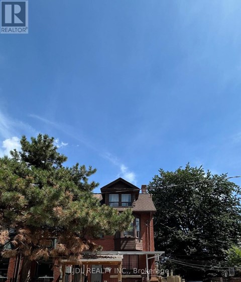 A building with a sign that says "IDI REALTY INC." is in front of some trees.