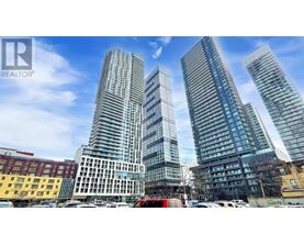 A cityscape with three tall buildings in the foreground and a clear blue sky above.