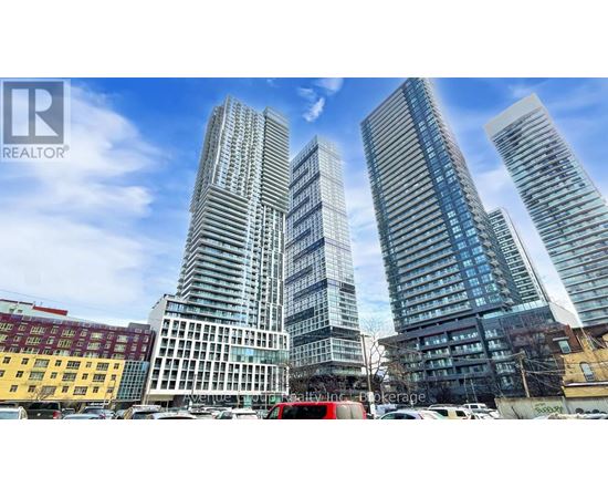 A cityscape with three tall buildings in the foreground and a clear blue sky above.