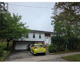 A yellow car is parked in front of a garage.