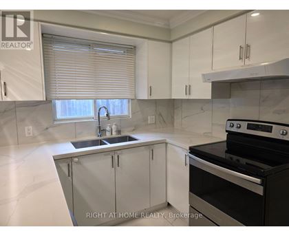 A modern kitchen with a stove top oven and a sink.
