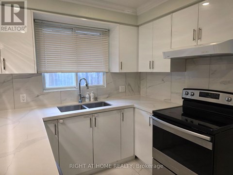 A modern kitchen with a stove top oven and a sink.