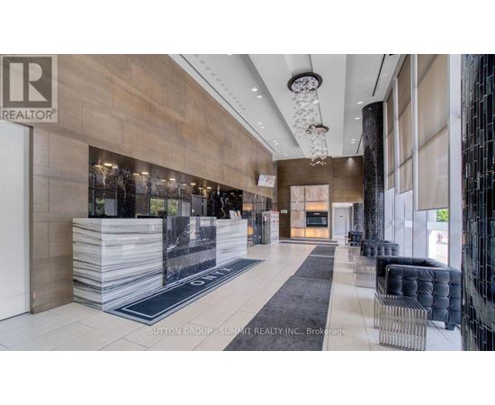 A modern lobby with a reception desk and a glass wall.
