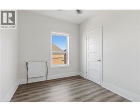 A room with a window, a door, and a radiator.