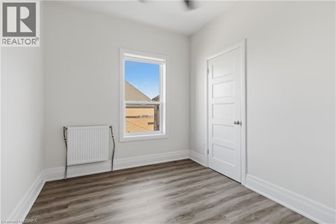 A room with a window, a door, and a radiator.